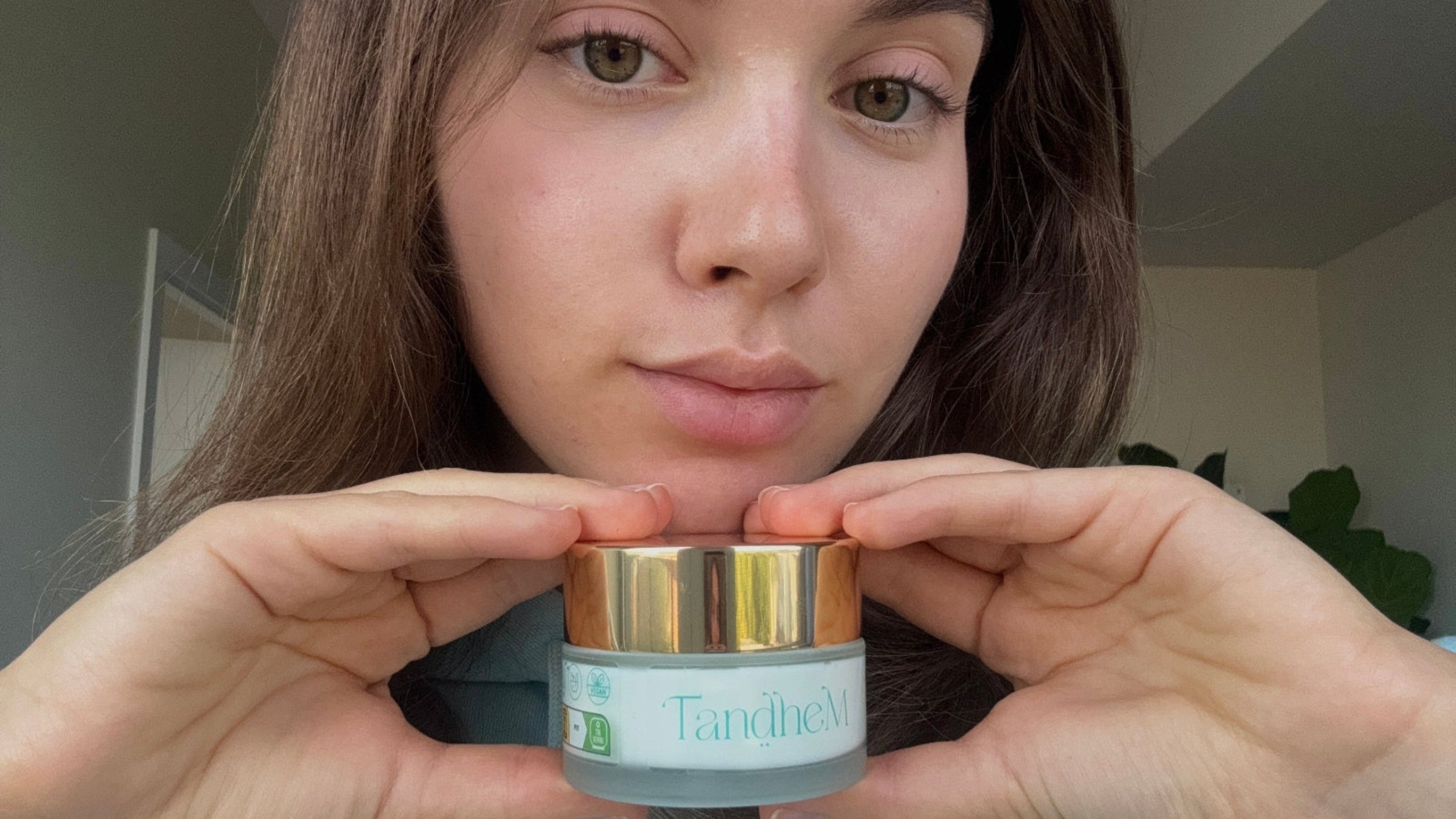 Person holding a TandheM face cream container